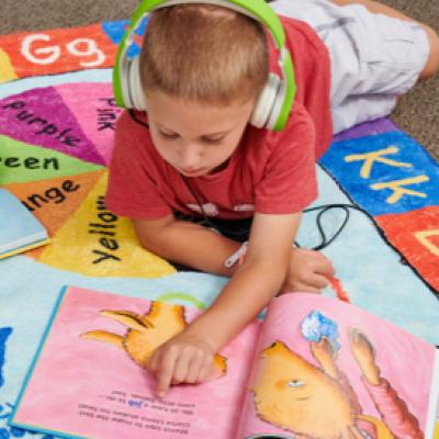 Child listening to a Wonderbook using headphones while reading along.