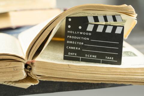 Photo of a movie clapboard in the pages of an old book