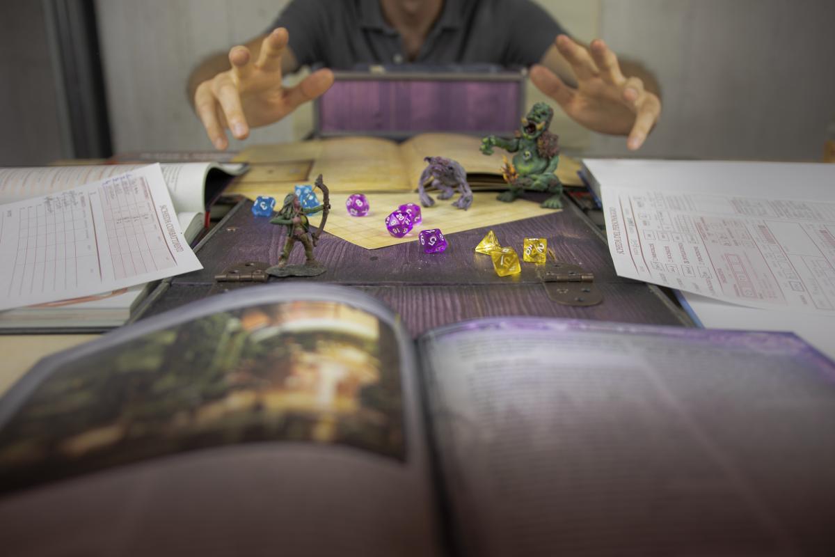 Photo of people playing a tabletop roleplaying game with colorful dice